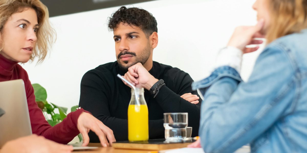 Individuals engaged in a serious yet reflective conversation, illustrating the nuanced humor of social satire.
