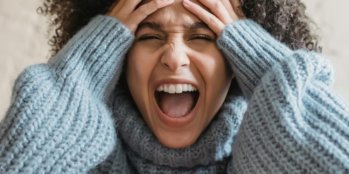 A person showing intense frustration while trying to deal with a difficult situation.