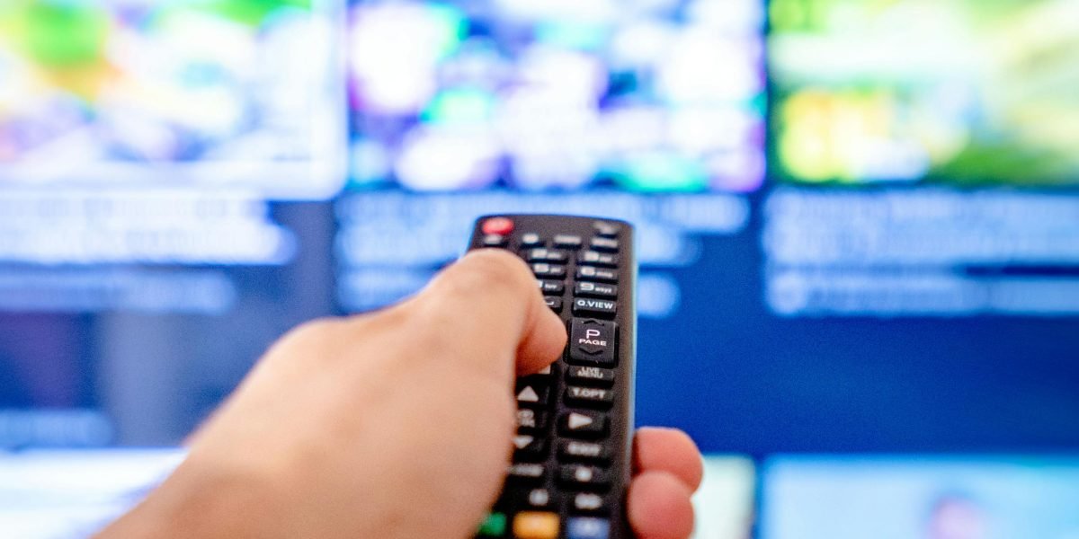 A young person absorbed in watching streaming content on a device, reflecting modern consumption of comedy.