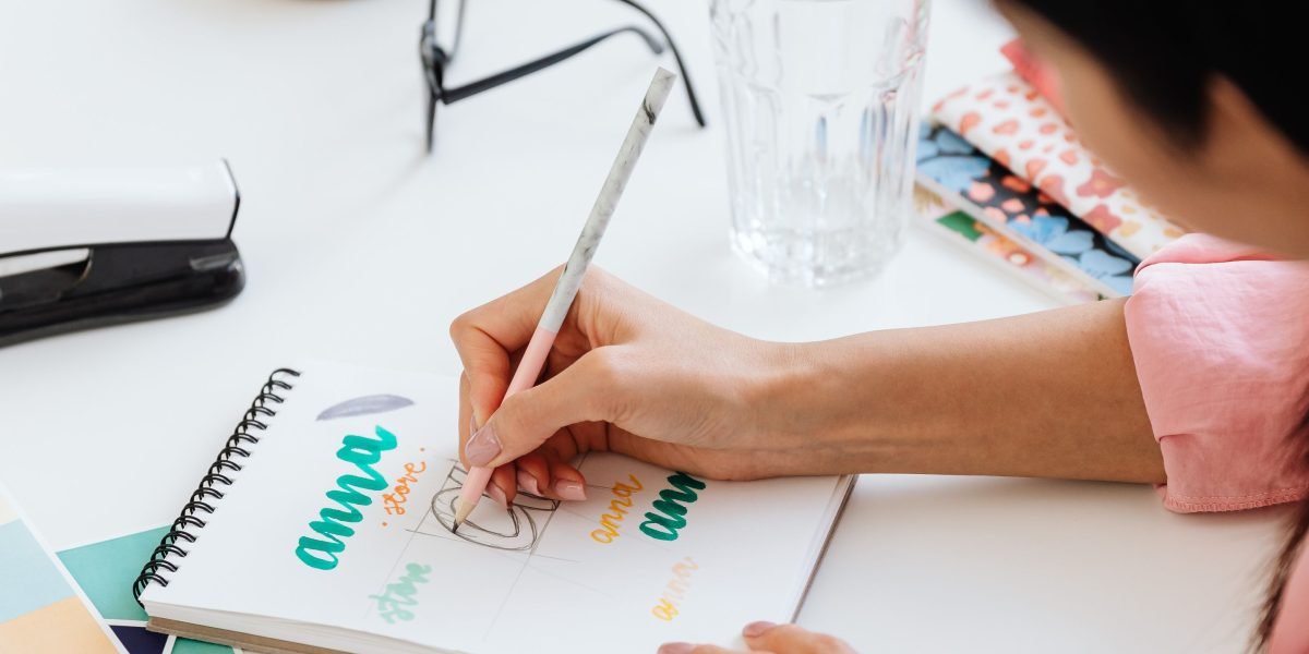 A person diligently writing notes, brainstorming ideas, and engaging in a creative thought process.